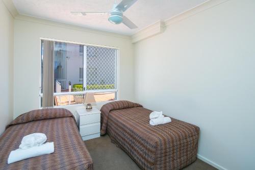 - 2 lits dans une chambre avec fenêtre dans l'établissement Bay Lodge Apartments, à Gold Coast
