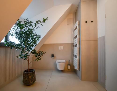 a bathroom with a toilet and a tree in it at DAS KEHRS - Hotel auf dem Petersberg in Erfurt