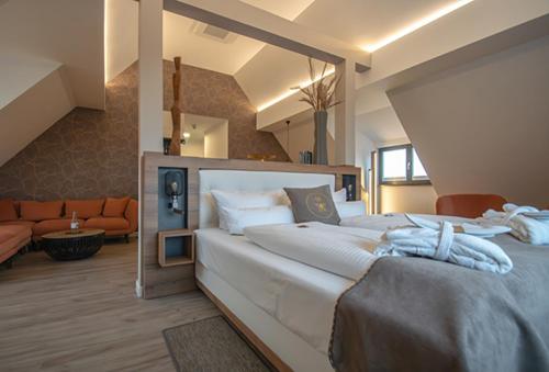 een groot wit bed in een kamer met een bank bij DAS KEHRS - Hotel auf dem Petersberg in Erfurt