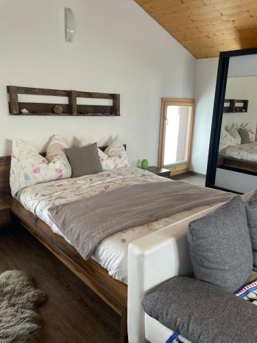 1 dormitorio con 1 cama grande y espejo en Chalet Sträba, en Bellwald