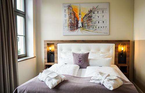 a bedroom with a bed with two towels on it at DAS KEHRS - Hotel auf dem Petersberg in Erfurt