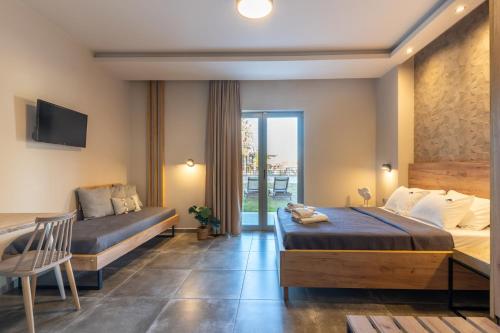 a hotel room with two beds and a balcony at Olympus Pantheon Luxury Rooms in Plaka Litochorou