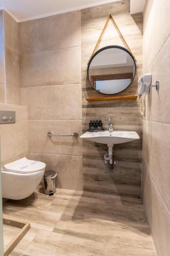 a bathroom with a sink and a mirror at Olympus Pantheon Luxury Rooms in Plaka Litochorou