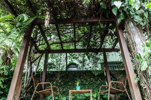 two chairs and a table in a garden at Pousada Vila da Praia in Bertioga