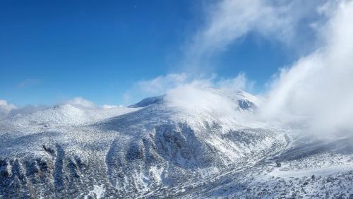 a mountain covered in snow on a cloudy day at Pinewood ANG premium luxurious apartment 15 in Borovets