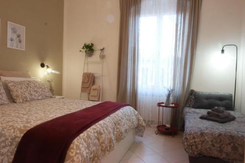 een slaapkamer met een bed, een raam en een stoel bij Il Nido di Marirò in La Spezia