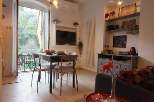een keuken en een woonkamer met een tafel en stoelen bij Il Nido di Marirò in La Spezia