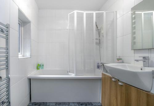 a white bathroom with a sink and a shower at 1 bedroom flat with 3 beds,Luton Town and station F3 53 in Luton