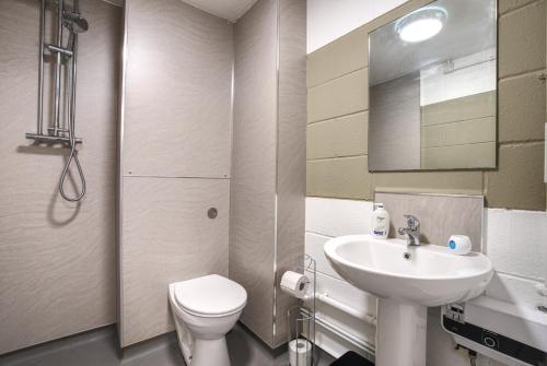 a white bathroom with a sink and a toilet at #10 Phoenix Court By DerBnB, Industrial Chic 1 Bedroom Apartment, Wi-Fi, Netflix & Within Walking Distance Of The City Centre in Sheffield