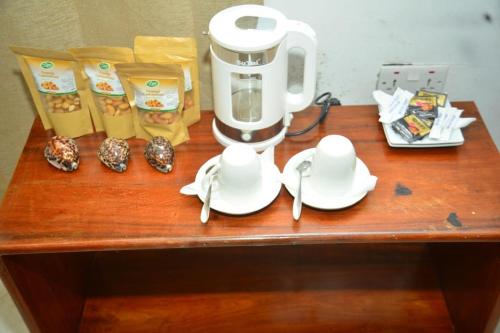 a table with a coffee maker and snacks on it at La Neisha Hotel Zanzibar in Stone Town