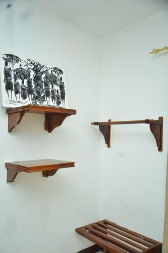 a wall with two wooden shelves on a wall at La Neisha Hotel Zanzibar in Stone Town