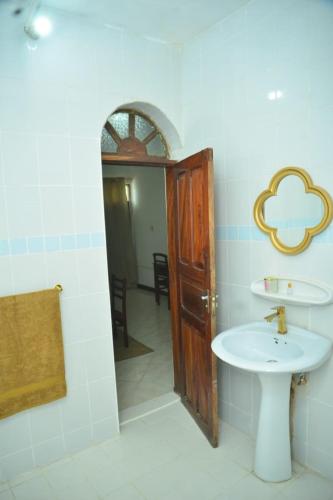 a bathroom with a sink and a mirror at La Neisha Hotel Zanzibar in Stone Town