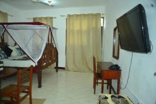 a living room with a flat screen tv on a wall at La Neisha Hotel Zanzibar in Stone Town