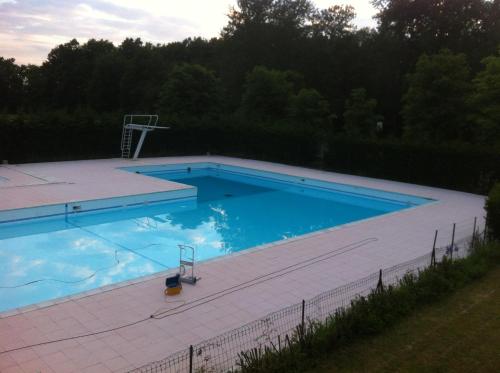 une grande piscine avec un panier de basket dans une cour dans l'établissement Maison reposante plein sud sans vis à vis avec piscine, à Le Châtelet-en-Brie