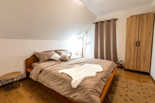 a bedroom with a bed with a white blanket on it at Vila Kristina in Andrijevica