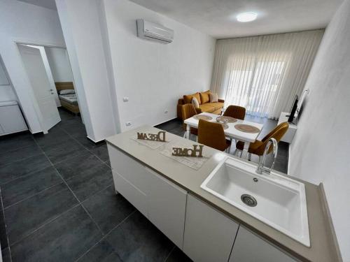a white kitchen with a sink and a dining room at Apartment Diego in Golem