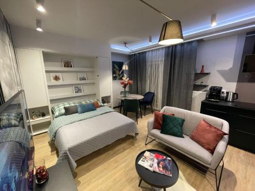 um quarto com uma cama, um sofá e uma mesa em New comfortable apartment with balcony and sauna on Klimieckiego street na Cracóvia