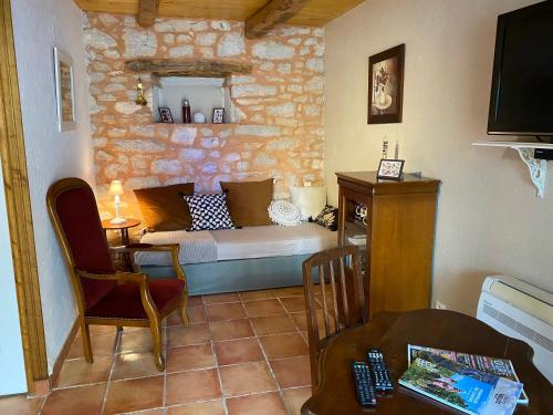 a bedroom with a bed and a chair in a room at LA FERME JARLAN in Berganty