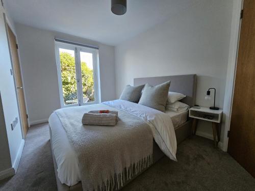 a white bedroom with a bed with a window at Eaglegate in Colchester