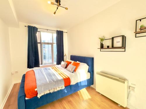 a bedroom with a blue bed and a window at Rooms Near Me - Apartment 3, Smart Tv, Free Parking in Halesowen