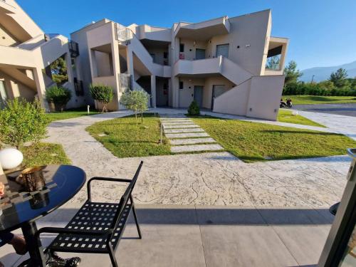 a building with a table and chairs in front of it at Olympus Pantheon Luxury Rooms in Plaka Litochorou