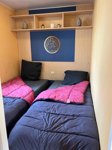 duas camas estão num pequeno quarto sem ermottermottermottermott em Mobil home 6 personnes - puy du fou em La Boissière-de-Montaigu