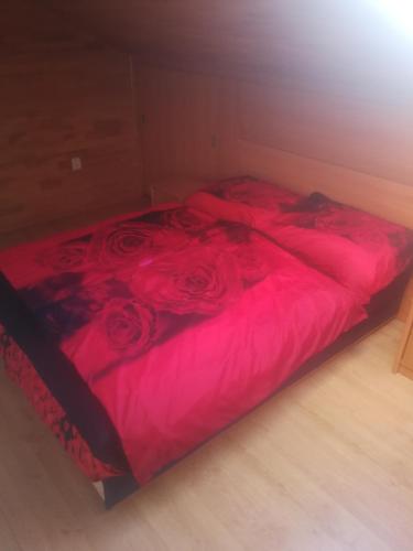 Una cama con sábanas rojas y rosas. en Villa Barrandovská, en Praga