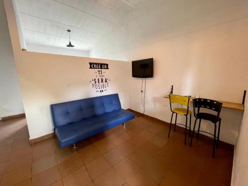 a blue couch in a room with a tv and chairs at OUR HOME SAN ANTONIO in Cali