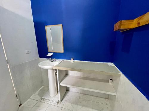 a blue bathroom with a sink and a mirror at OUR HOME SAN ANTONIO in Cali