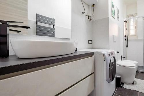 bagno bianco con lavandino e servizi igienici di A.P. Appartamento o camera a Corsico