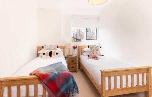 two twin beds in a bedroom with white walls at Rousdon Mist in Rousdon