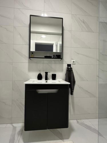 a bathroom with a black sink and a mirror at Restoran&Motel and apartmants Lovacka prica in Tešanj