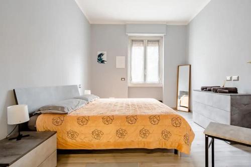 biała sypialnia z łóżkiem i lustrem w obiekcie A.P. Appartamento o camera w mieście Corsico