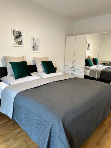 um quarto com uma cama grande e almofadas verdes em Harmony Living - 10 min to Graz em Lassnitzhöhe