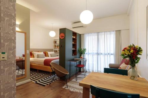 um quarto de hotel com uma cama e uma sala de estar em L.A.R. Jardins. Limpeza diária, vaga e bikes em São Paulo