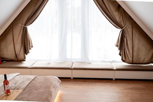 a couch sitting in front of a large window at Pod Kalwarią in Nowosiółki Dydyńskie