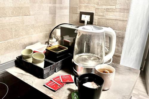 a counter top with a blender and cups on it at A.P. Appartamento o camera in Corsico