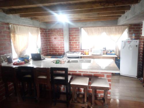 eine Küche mit einem Tisch und Stühlen sowie einem Kühlschrank in der Unterkunft Mamá Naty y sus Neguitos in Chambo