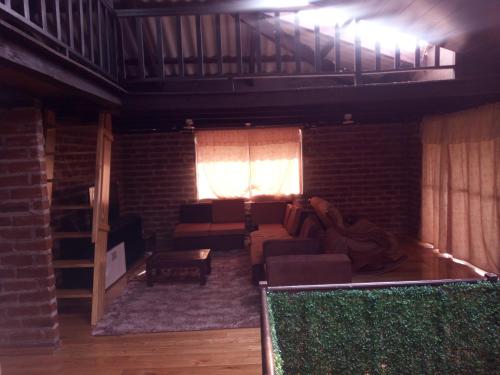 ein Wohnzimmer mit Sofa und Ziegelwand in der Unterkunft Mamá Naty y sus Neguitos in Chambo