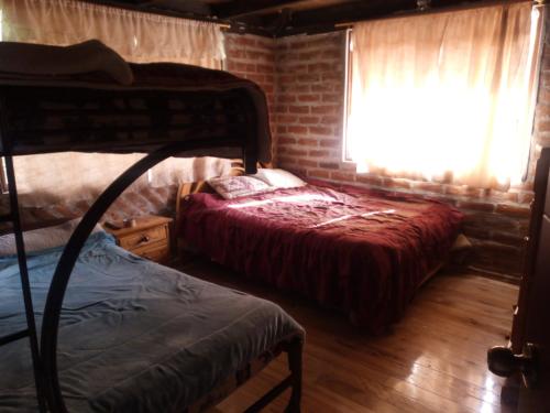 a bedroom with two bunk beds and a window at Mamá Naty y sus Neguitos in Chambo