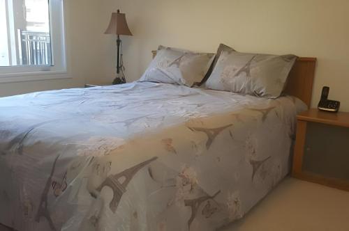 a bedroom with a bed with a white comforter at Specious 2 Bedroom Condo in Collingwood in Collingwood