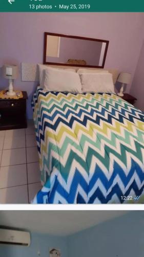 um quarto com uma cama com um edredão colorido em The Cliff Apartments em Beverly Hills