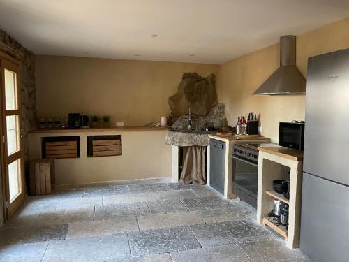 une cuisine avec une cuisinière et un réfrigérateur dans l'établissement Villa proche plage extrême sud Corse, à Monacia-dʼAullène