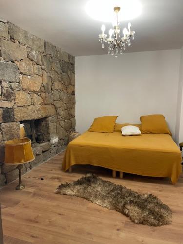 une chambre avec un lit et un mur en pierre dans l'établissement Villa proche plage extrême sud Corse, à Monacia-dʼAullène