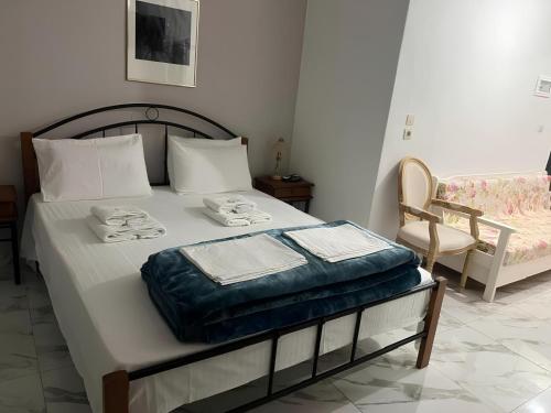a bedroom with a bed with towels and a chair at Villa Askamnia and Suites in Nikiti