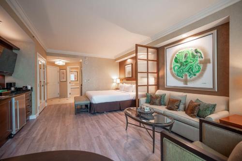 une chambre d'hôtel avec un lit et un canapé dans l'établissement No Resort Fee Strip View Suite + Free Valet + Pool, à Las Vegas