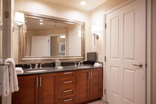 拉斯維加斯的住宿－No Resort Fee Strip View Suite + Free Valet + Pool，一间带两个盥洗盆和大镜子的浴室