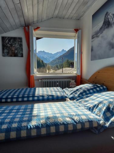 una camera con due letti e una finestra con vista sulle montagne di Gästehaus Gruben a Oberstdorf