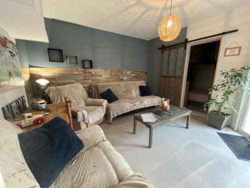 un salon avec deux canapés et une table dans l'établissement Charmant T2, Cl 3 étoiles, 4 Lits, 4 personnes et 1enfant, parking et terrasse, à Saint-Sever