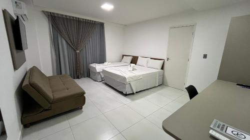 a hotel room with a bed and a chair at EL SHADDAI HOTEL in João Pessoa